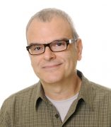 Fabio Miranda is smiling directly at the camera with brown eyes, hair, and glasses.