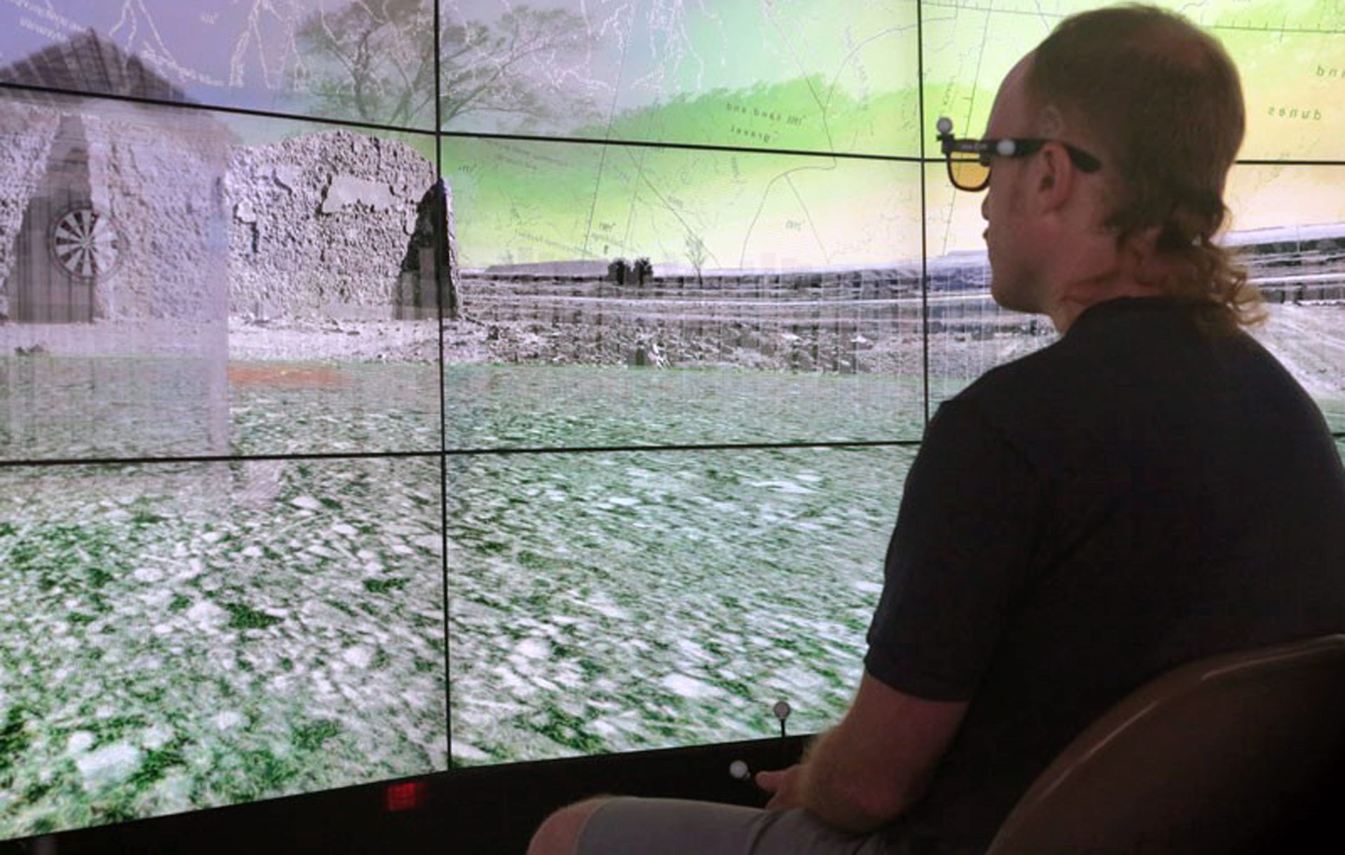 &ldquo;Hearts and Minds&rdquo; shown in the CAVE2&trade; virtual-reality environment. Performer wears stereo glasses with markers for wireless tracking and holds a wand controller for interacting with virtual objects in the scene.