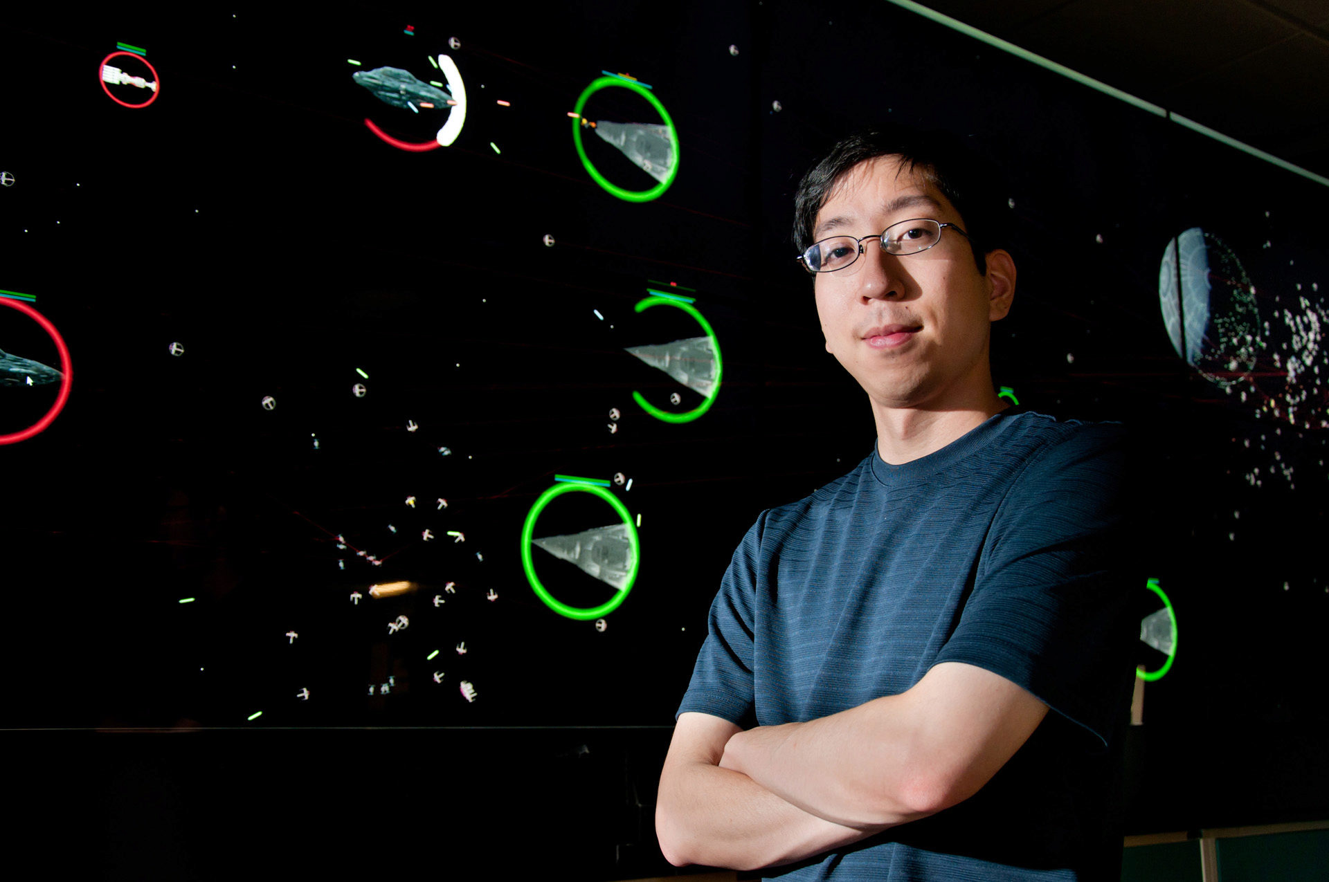 Arthur Nishimoto stands in front of EVL’s Cyber-Commons that is running his video game &ldquo;Fleet Commander,&rdquo; an homage to the epic battles in Star Wars&rsquo; Return of the Jedi.